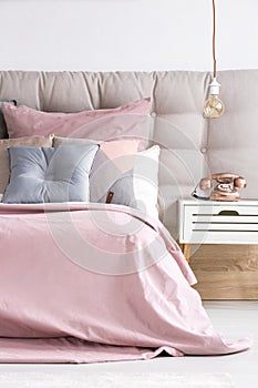 Bed with soft pink coverlet photo