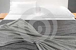 Bed with striped cover and white pillows