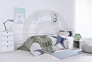 Bed with stylish linens in children`s room