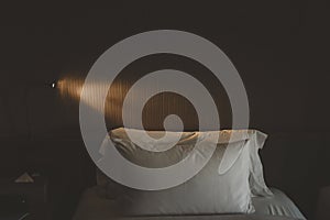 Bed with white linens with lamp in a hotel