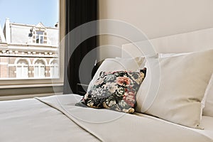 a pillow on a bed in front of a window