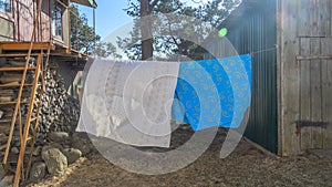 Bedding sheets drying on the clothesline outside. Lens flare. Bed linen drying on a clothes line in the garden