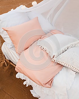 Bedlinen on a white bed .Bed with decorative pillows and duvet .Outdoor.