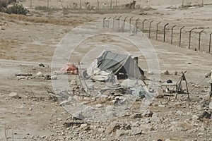 Bedouin houses in the desert near Dead Sea. Poor regions of the world. A indigent Bedouin sitting at the tent. Poverty in Jordan.