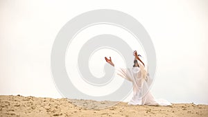 Bedouin raising palms to sky, asking Allah for help and mercy, praying on knees