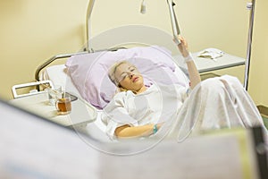 Bedridden female patient recovering after surgery in hospital care.