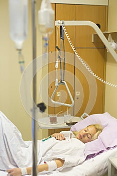 Bedridden female patient recovering after surgery in hospital care.