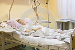 Bedridden female patient recovering after surgery in hospital care. photo