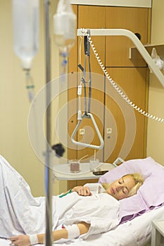 Bedridden female patient recovering after surgery in hospital care. photo