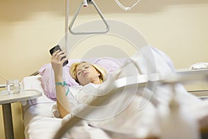 Bedridden female patient recovering after surgery in hospital care. photo