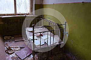 Bedroom in abandoned kindergarten in destroyed village of Kopachi 10 km exclusion zone of Chernobyl NPP, Ukraine