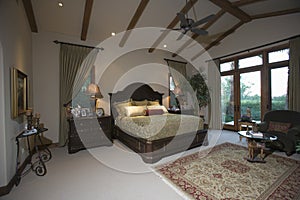 Bedroom With Beamed Ceiling And Patio Doors