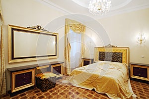 Bedroom with beautiful bed, bedside tables and big mirror