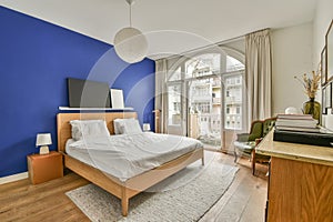 a bedroom with a bed and a blue accent wall