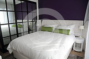Bedroom with big duble bed and wall mirror photo