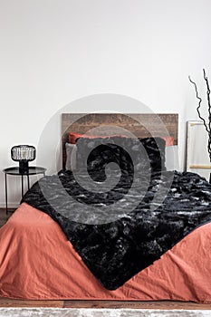 Bedroom with black blanket and coral bedsheets