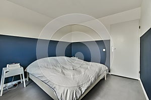 a bedroom with a blue wall and a white bed