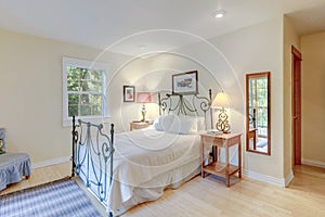 Bedroom bright interior with metal bed and sliding door to the balcony with chair, country style of American cozy home with light