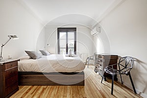 bedroom with a dark wooden bed, white lamps on the bedside tables,