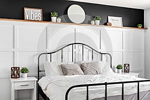 A bedroom detail with wainscoting and decorations on a wood shelf.