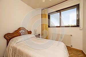 Bedroom with double bed with tacky wooden headboard in a room