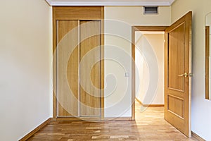 Bedroom in an empty room with a mirror attached to the wall, ducted air conditioning and French oak flooring and an entrance door photo