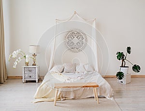 Bedroom with four-poster bed, bedside tables and flowers