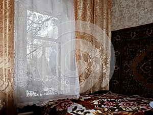 Bedroom in grandma's house with yellow curtains and vintage interior with old wooden window frame open to spring