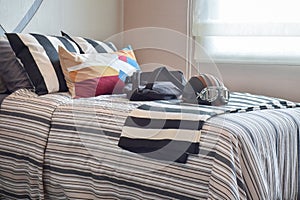 Bedroom with helmet and bag on striped bedding