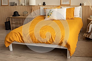 Bedroom interior bed in the interior, linen orange yellow bed linen . Lemon print.