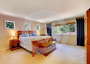 Bedroom interior with beige carpet floor and dark blue curtains.