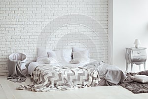 Bedroom interior with a brick wall with a bed and bedside tables