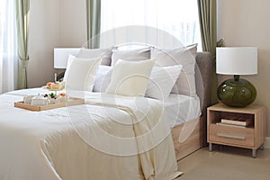 Bedroom interior with decorative tea set and dessert on bed