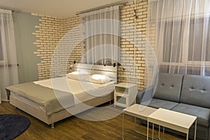 Bedroom interior, double bed, sofa and large windows