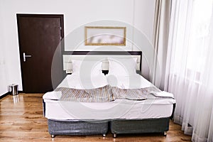 Bedroom interior in light colors, family bed. The concept of home comfort in the hotel.elegant classic