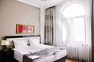 Bedroom interior in light and sand tones, bed and window