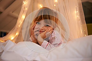 Bedroom, lights and portrait of child at night for resting, relaxing and dreaming in home. Happy, smile and face of