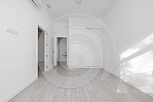 Bedroom of a loft-type home with a white built-in wardrobe and a suite-type bathroom