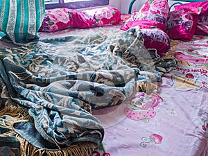 The bedroom is a mess. A child\'s room with a messy bed and pillows, bolsters and quilts that have not been tidied up