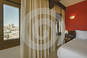 Bedroom with old wooden headboard, curtains on the windows