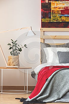 Bedroom with plant, lamp and painting