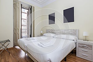 bedroom with two beds together with white bedding, wooden headboard