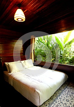 The bedroom where the window takes in the breeze overlooks the trees outside