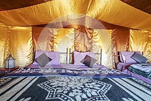 Beds inside elegant tent set on Sahara desert, Morocco