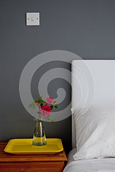 Bedside table with a rose and a tray