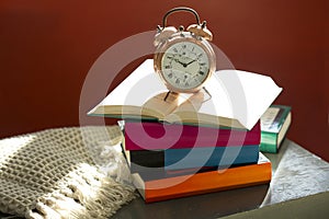 Bedtime reading, alarm clock and books on bedside table