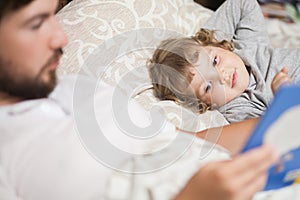 Bedtime Story. Dad and daughter read a book.