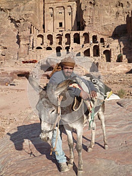 Beduin leaning against his donkey in Petra Jordan