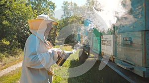 Bee-maker beekeeper lifestyle man working of a smoke pipe beeper smoker device for repelling evil bees. slow motion