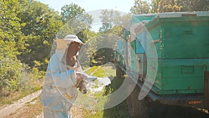 Bee-maker beekeeper man working of a smoke lifestyle pipe beeper smoker device for repelling evil bees. slow motion